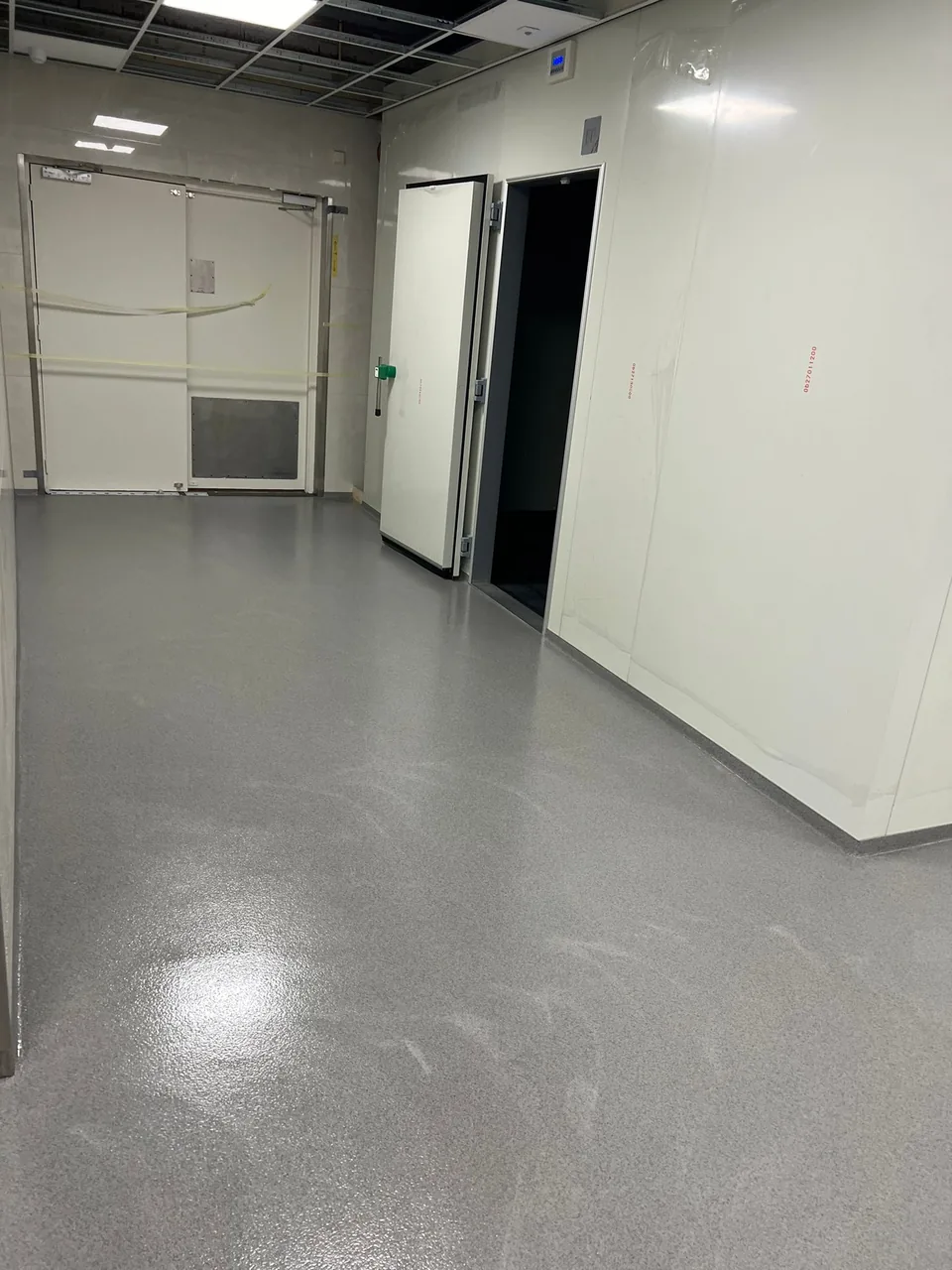 Grey quartz floor in a production corridor with white sandwich panels