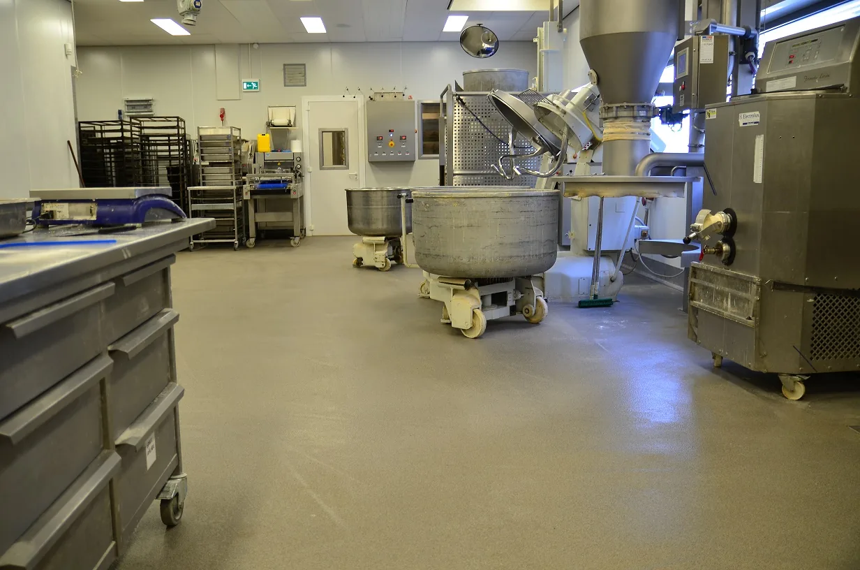 Seamless Comforcon QCF resin floor in a food production area with coved skirting along the wall