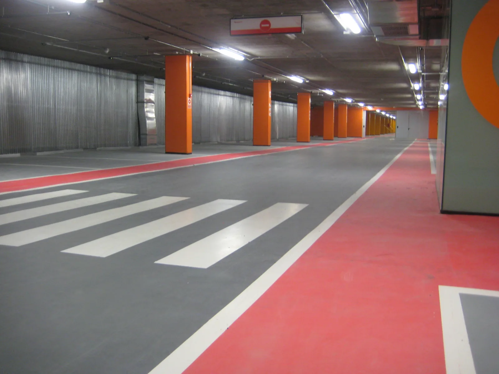 Comforpark Deck car park deck coating in a car park with a red lane, grey parking bays and orange columns