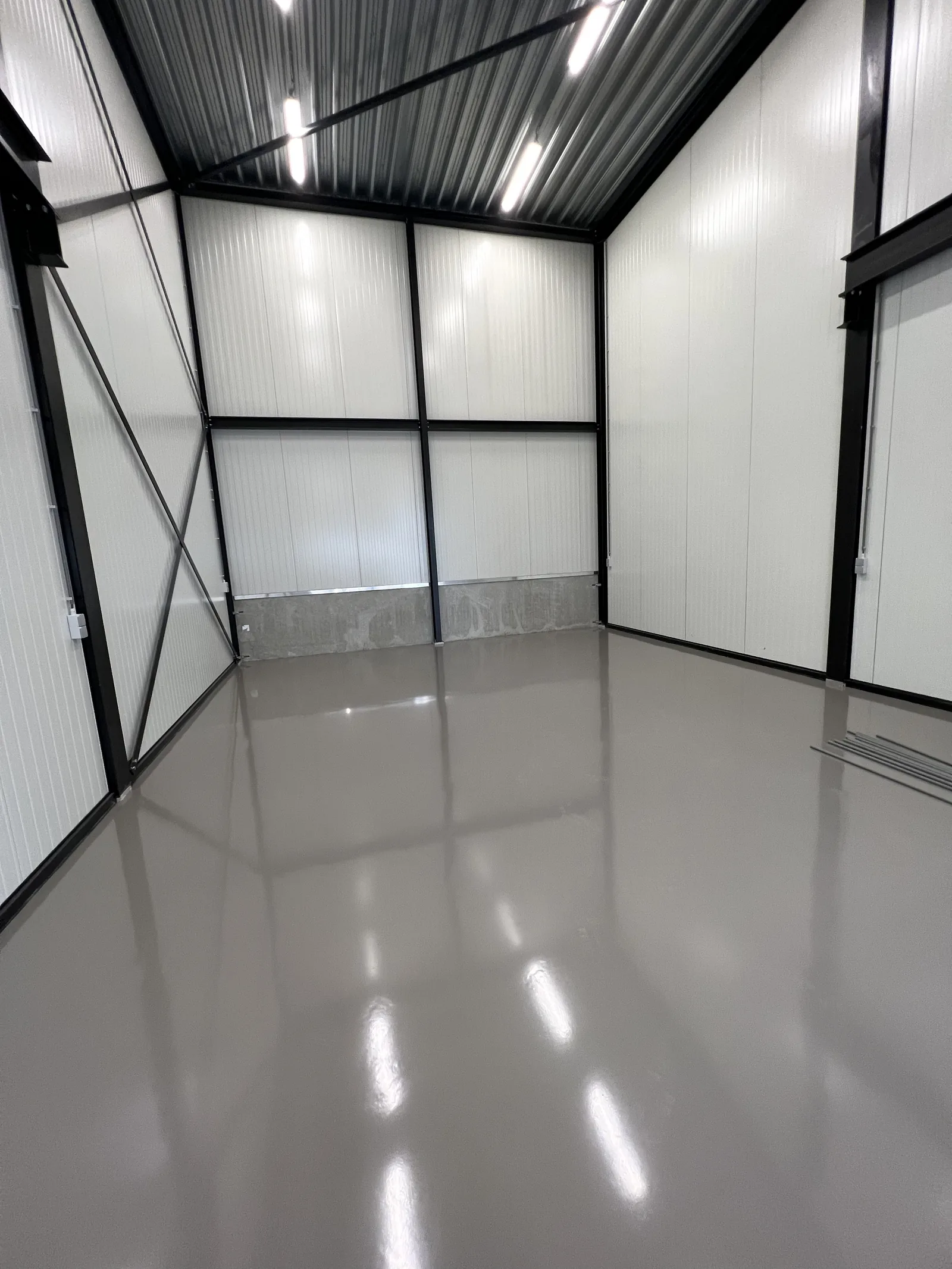 Anthracite grey epoxy resin floor in a new outbuilding with white wall panels
