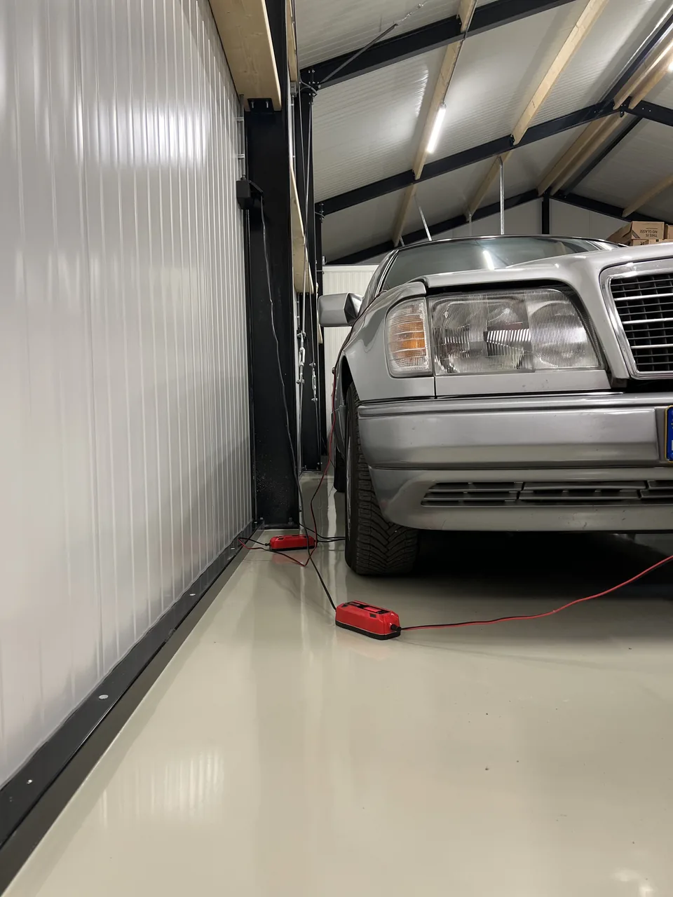 Grey epoxy resin floor beneath a vehicle lift in a private garage
