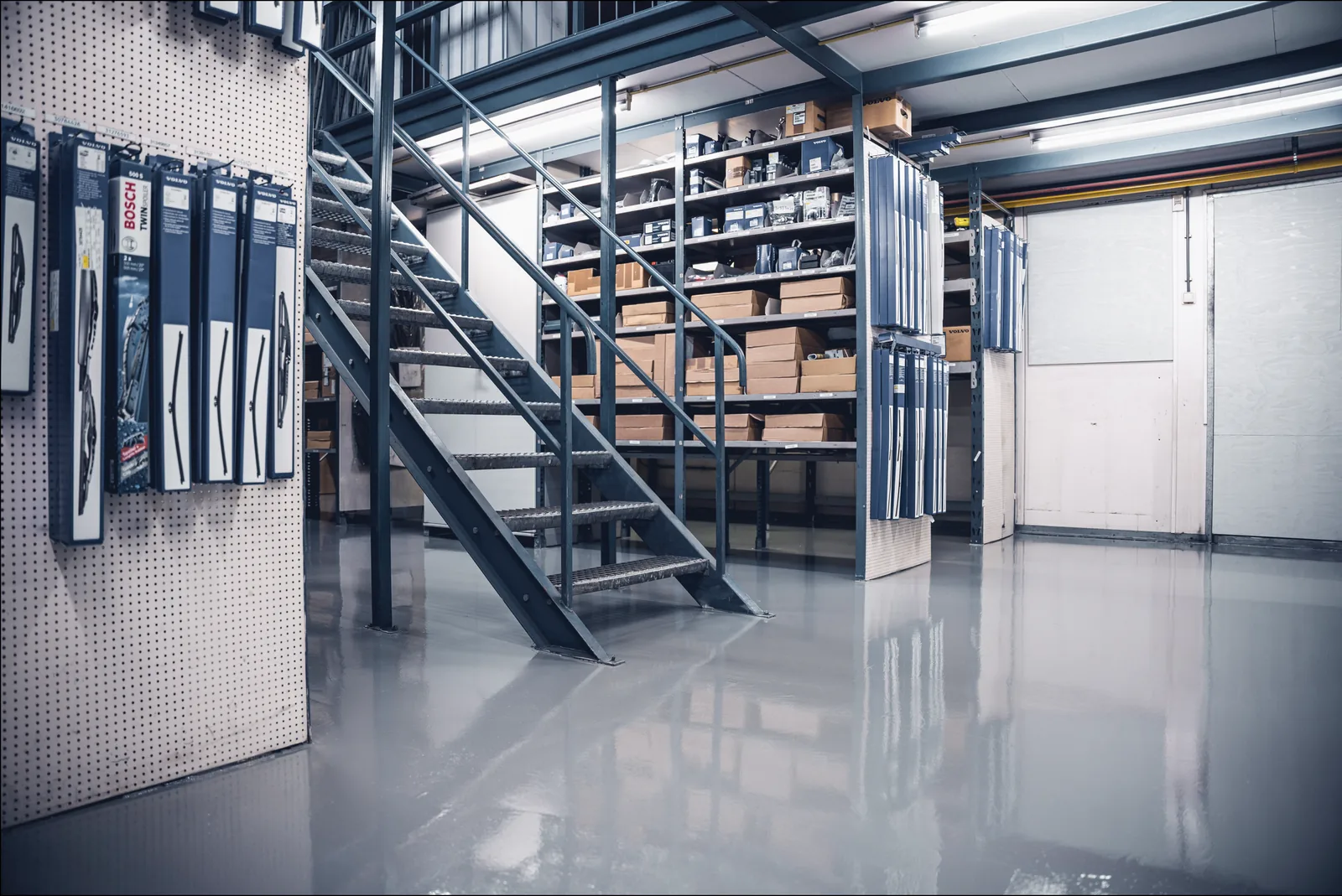 Epoxy coating on a mezzanine floor with a steel staircase and warehouse racking