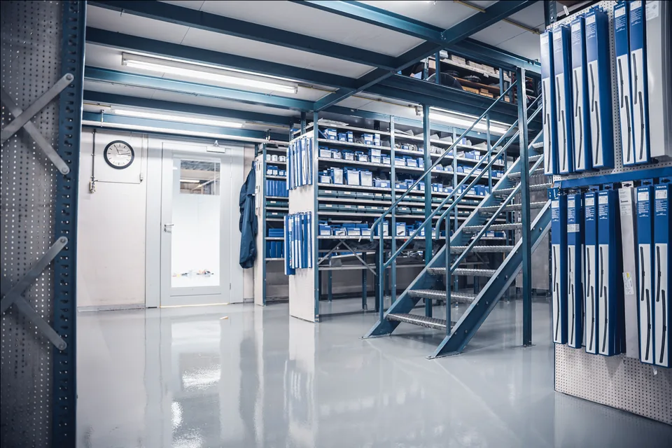 Blue-grey epoxy coating on a mezzanine with racking full of parts