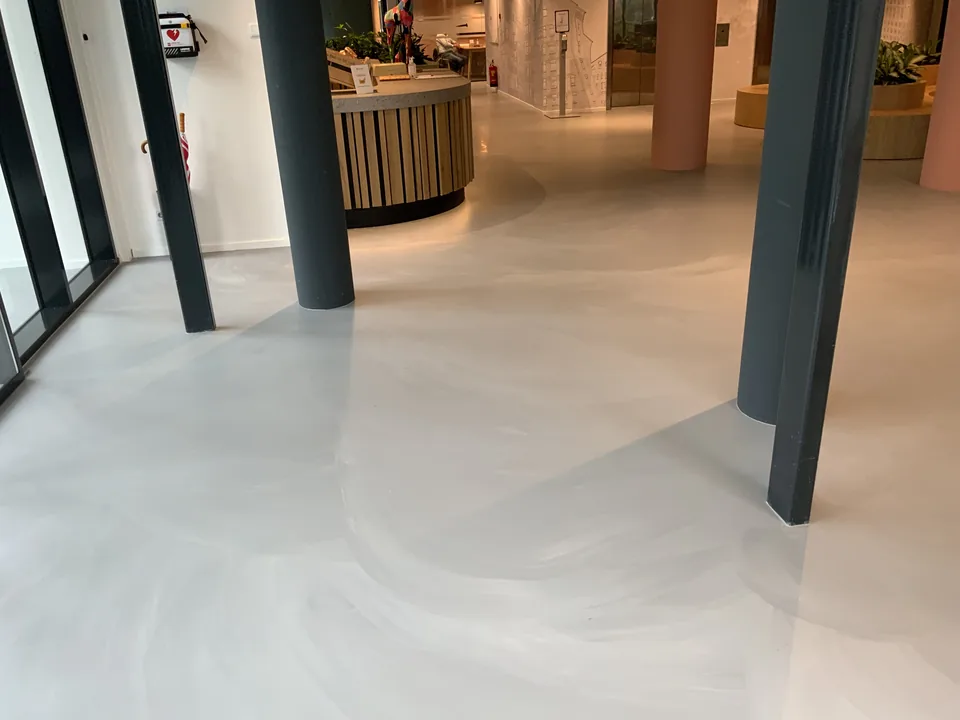 Concrete-look resin floor in a staff restaurant with a bar and seating areas