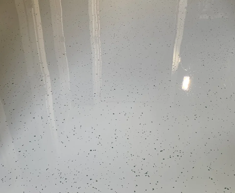 Close-up of a white Comforpur 670 Deco resin floor with fine dark flakes