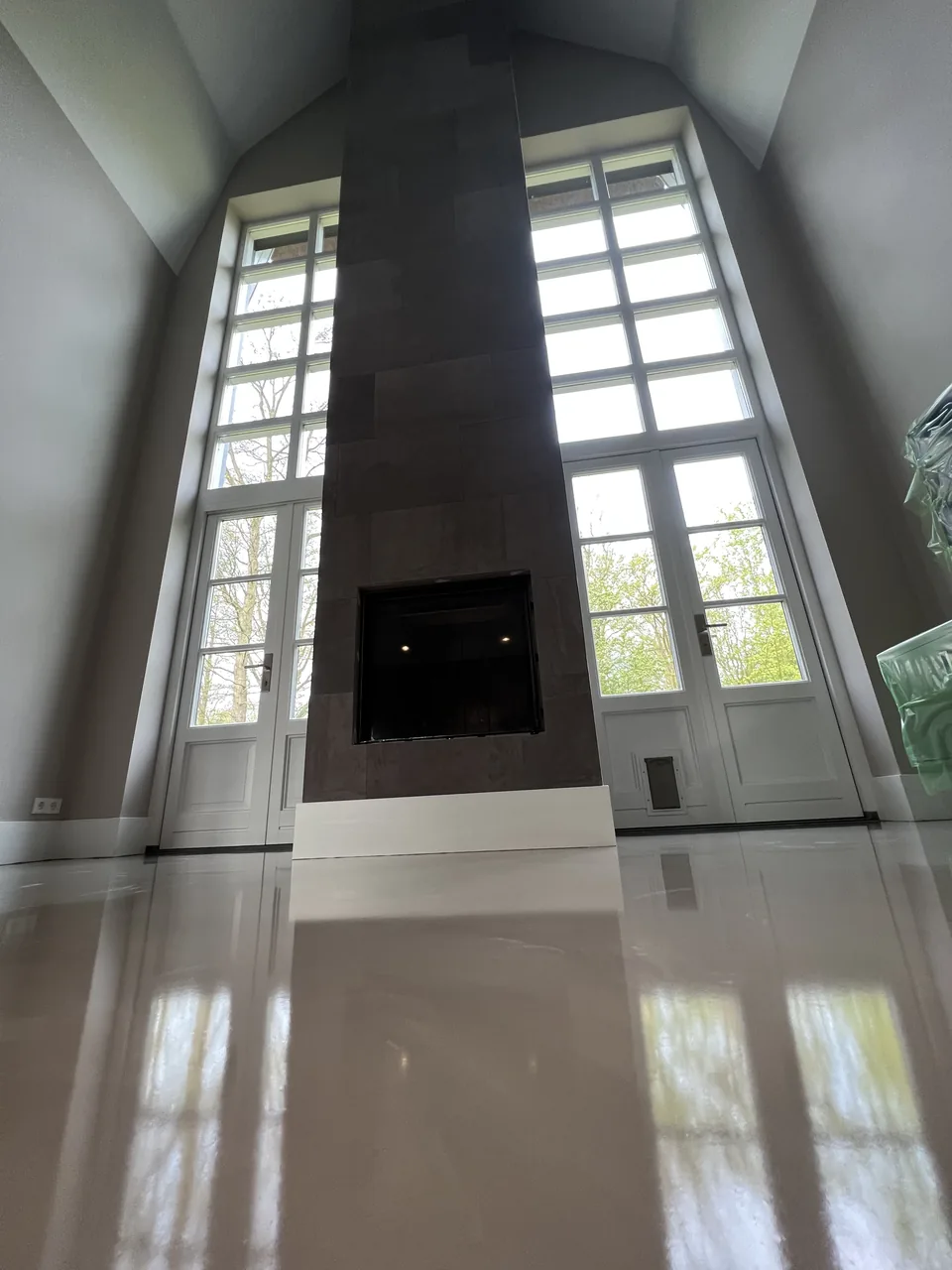 Reflective resin floor in a living room with a black fireplace wall