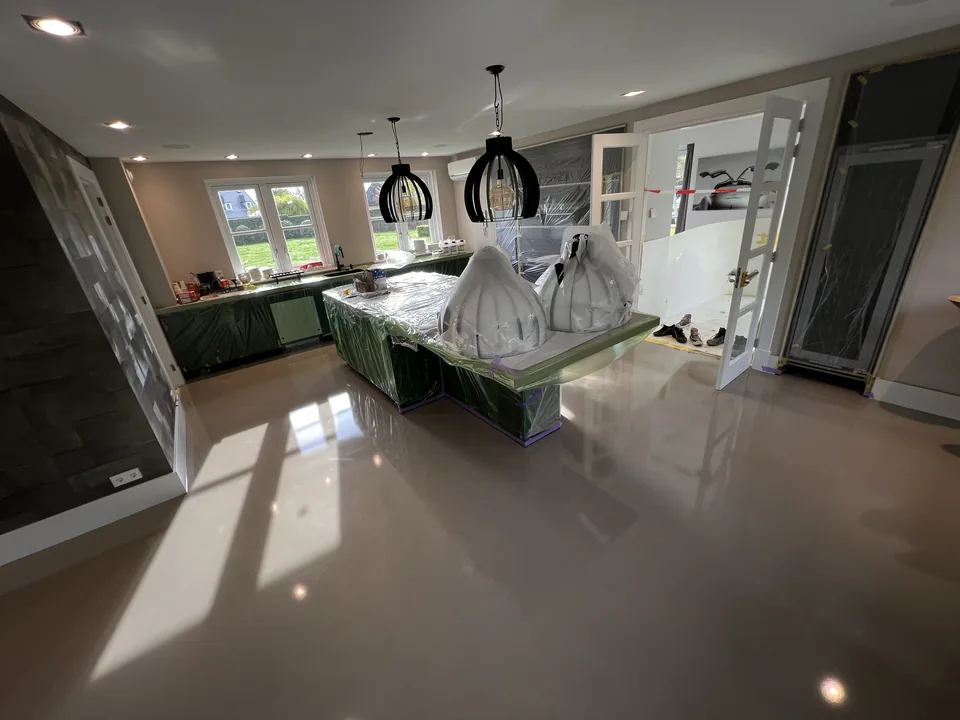 Glossy resin floor in a kitchen-diner with a large cooking island and tall windows