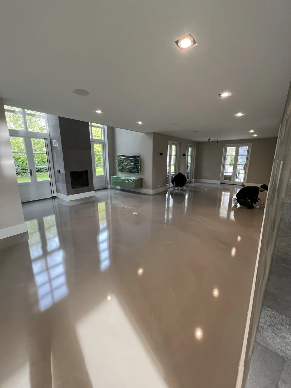 High-gloss Comforpur 690 Greenline resin floor in a living room with French doors to the garden