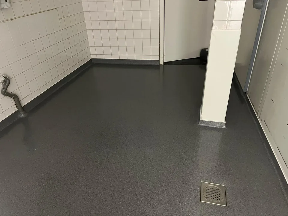 Grey quartz floor with a floor drain in a tiled cold store
